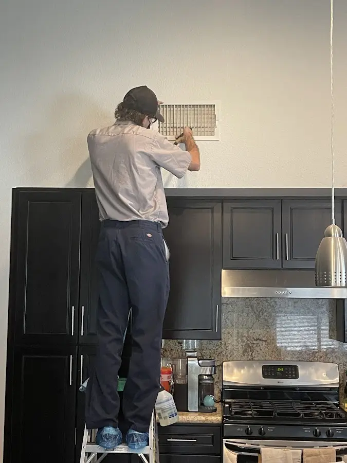 Technician inspecting an air vent during HVAC service in Lago Vista